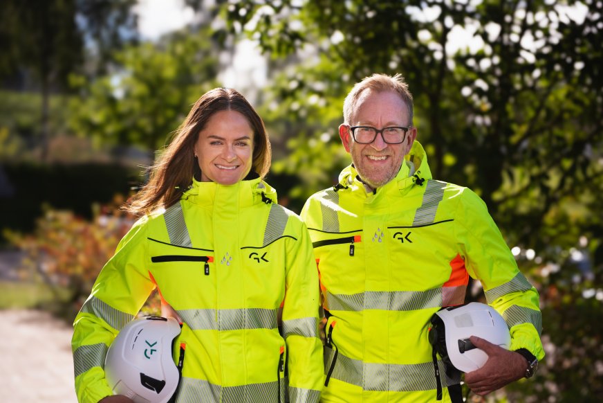 HMS-sjef Martine Drevvatne og Kim Robert Lisø, konsernsjef i arbeidstøy med arbeidshjelm i hånden.