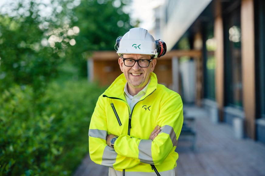 Bilde av Kim Robert Lisø, konsernsjef i GK, utenfor Miljøhuset Ryen i arbeidstøy og hjelm.